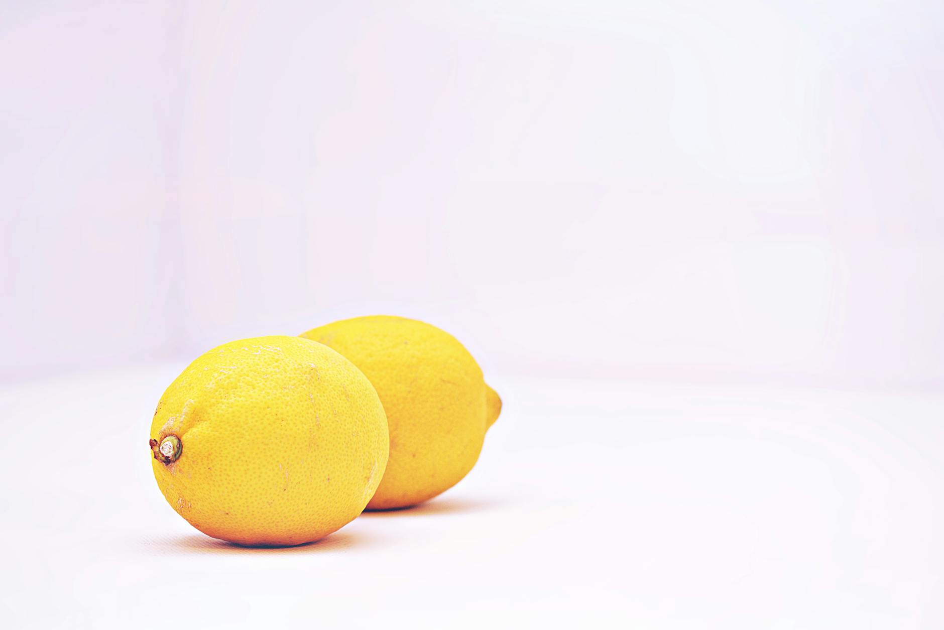 Two vibrant lemons on a white background, symbolizing the fresh simplicity of the Lem vibrator design